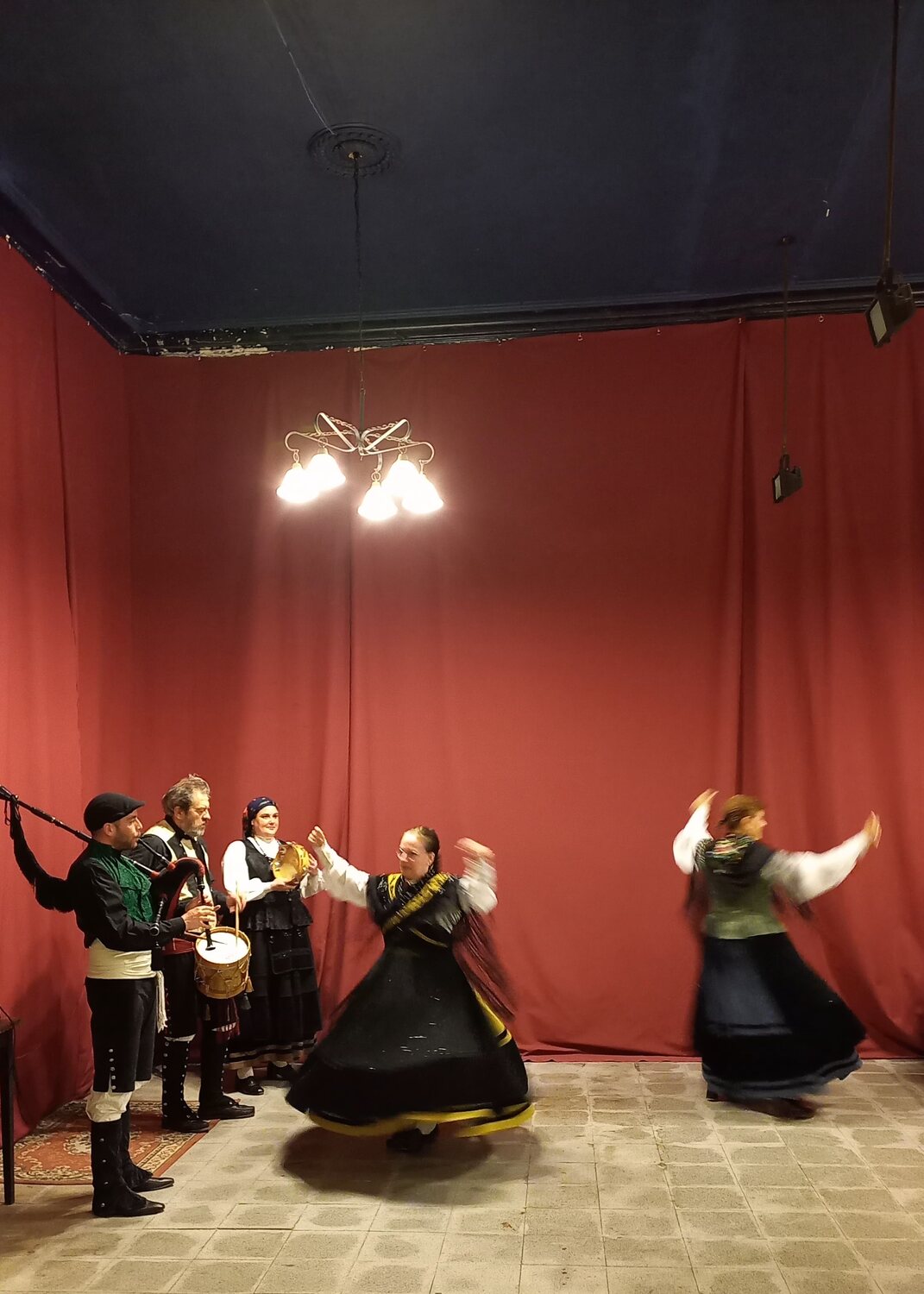 Bailarinas y gaiteiros durante una presentación en el salón.