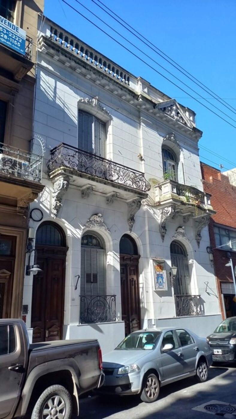 La fachada de Piedras 848 vista desde la vereda de enfrente, en un día de sol, con la cuadra de San Telmo alrededor.