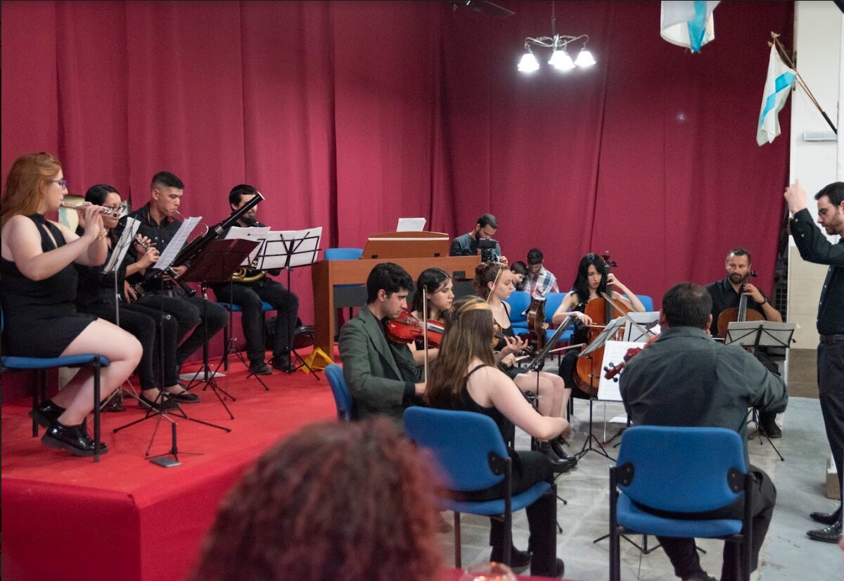 Orquesta tocando en el salón, con la bandera gallega colgada al fondo.